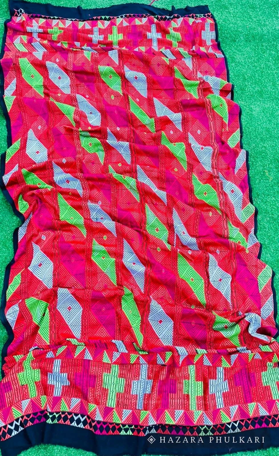 Full view of a densely embroidered Bagh Phulkari shawl with diagonal geometric motifs on a black ground fabric
