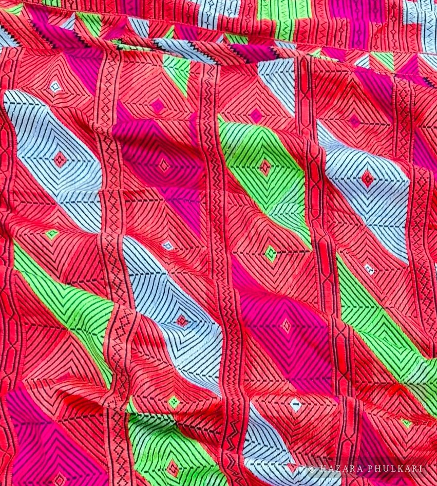 Close-up of Phulkari hand embroidery showing counted-thread stitches forming diamond motifs