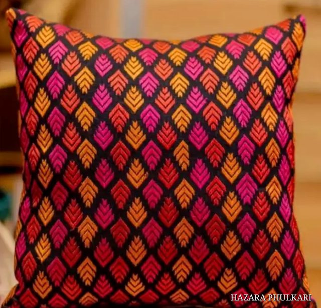 Phulkari cushion cover embroidered with orange, red and magenta leaf motifs in a dense lattice on black fabric