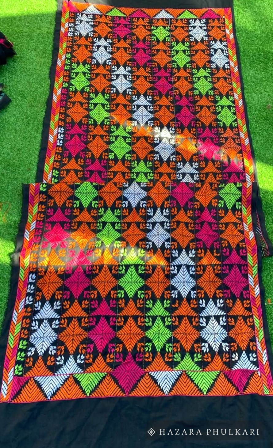 Two handmade Phulkari shawls with orange, pink and green leaf motifs embroidered on black fabric